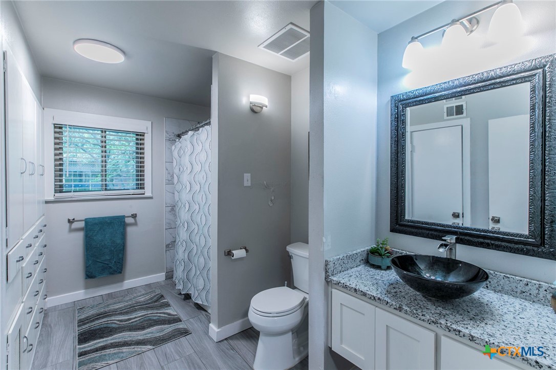 2518 Marlandwood Road Temple, TX 76502 - Photo 31 of 48 a bathroom with a granite countertop sink and a mirror