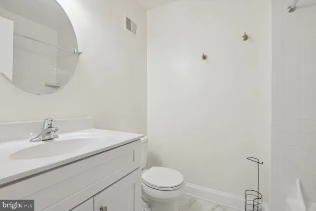 a bathroom with a sink a toilet and a mirror