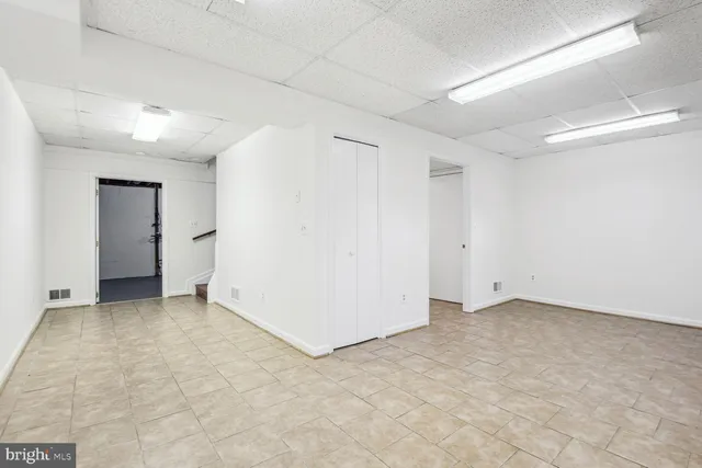 an empty room with closet and windows