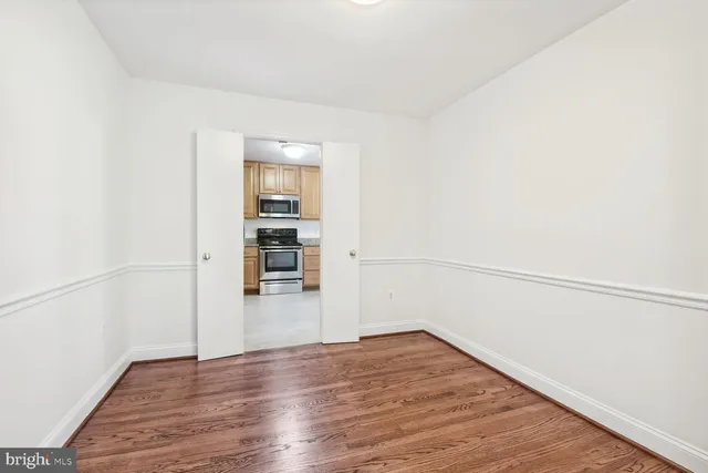 a view of empty room with wooden floor and cabinet