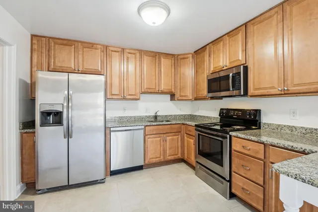 a kitchen with stainless steel appliances granite countertop a refrigerator stove microwave and sink