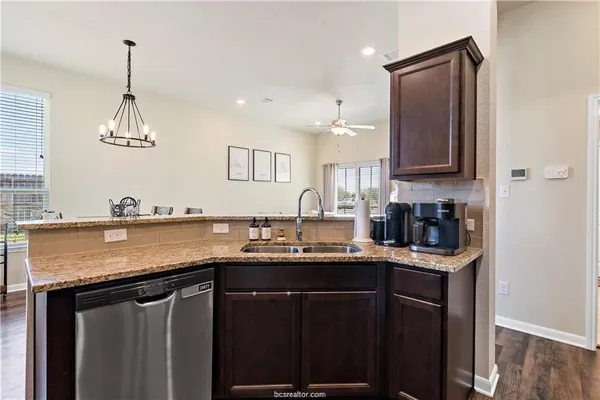 a kitchen with stainless steel appliances granite countertop a sink stove and cabinets