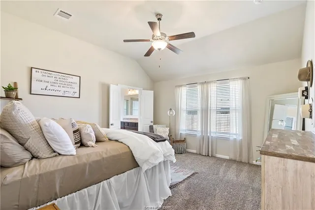 a bedroom with a large bed and a chandelier
