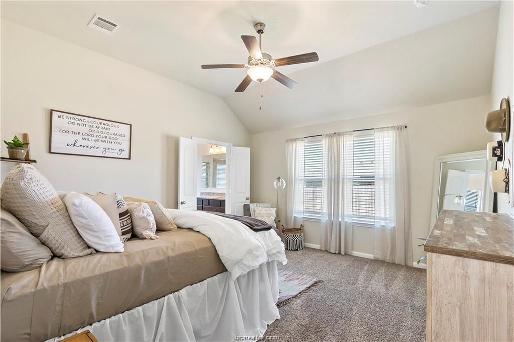 2000 Bleeker Cove Bryan, TX 77807 - Photo 16 of 24 a bedroom with a large bed and a chandelier