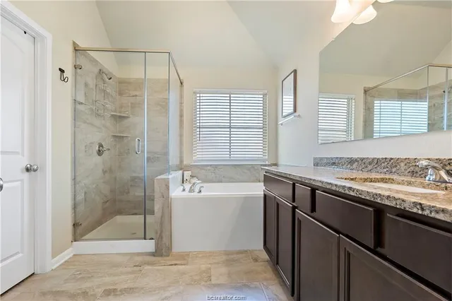 a bathroom with a granite countertop sink a toilet and shower