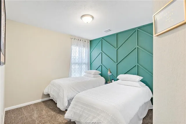 a bedroom with two beds and a window