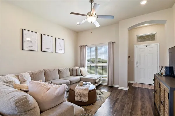 a living room with furniture and a flat screen tv with wooden floor