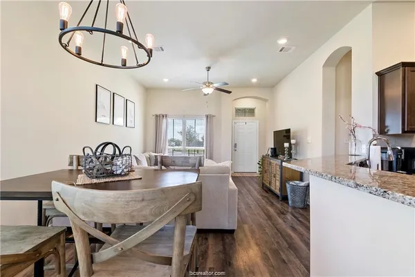 a view of a dining room with furniture a chandelier and wooden floor