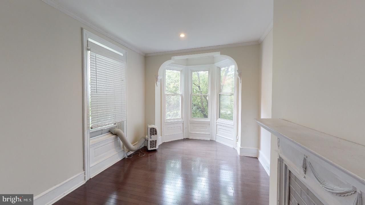2312 Locust Street, Unit 2R Philadelphia, PA 19103 - Photo 5 of 13 a view of an empty room with a window and wooden floor