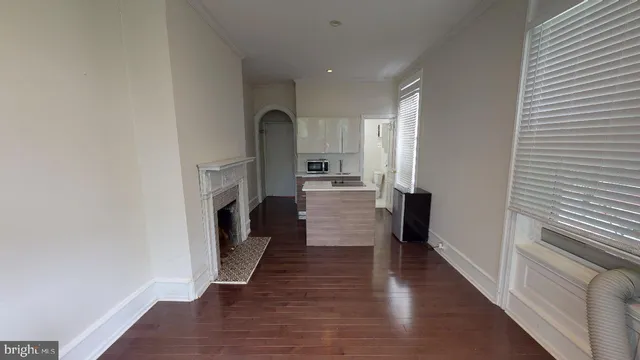 a view of a hallway with wooden floor and a fireplace