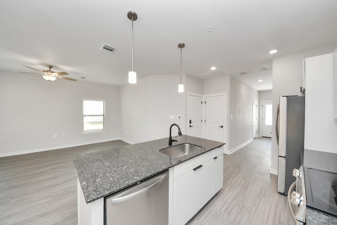 7711 Longmire Road, Unit 155 Conroe, TX 77304 - Photo 41 of 48 Boasting luxury finishes-stylish Island kitchen,granite counters,subway tile backsplash,ample custom cabinet space,stainless appliances,refrigerator,full size washer&dryer included,wood-like floors throughout,open concept floor plan.