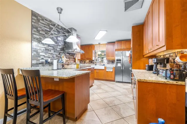 a kitchen with stainless steel appliances granite countertop a stove a sink and a refrigerator