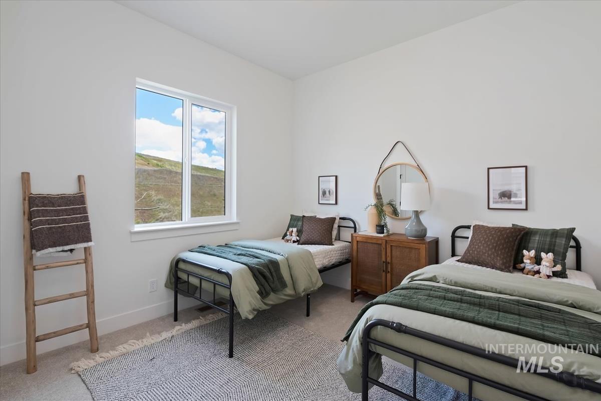 7615 Brown Way Eagle, ID 83714 - Photo 36 of 43 Bright room featuring a large window, neutral wall paint, and light-toned carpet flooring