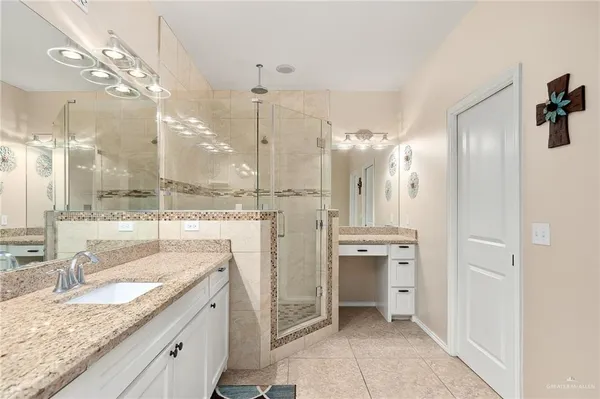 a bathroom with a granite countertop sink mirror and a shower