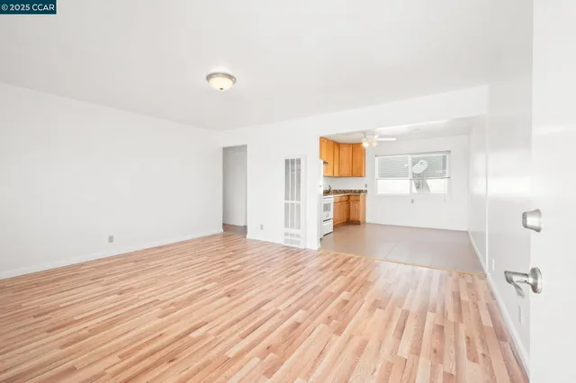 a view of empty room with wooden floor and window