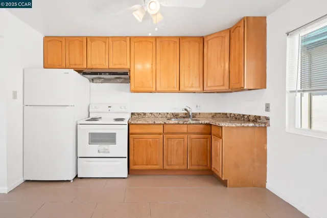 a kitchen with granite countertop white cabinets and white appliances