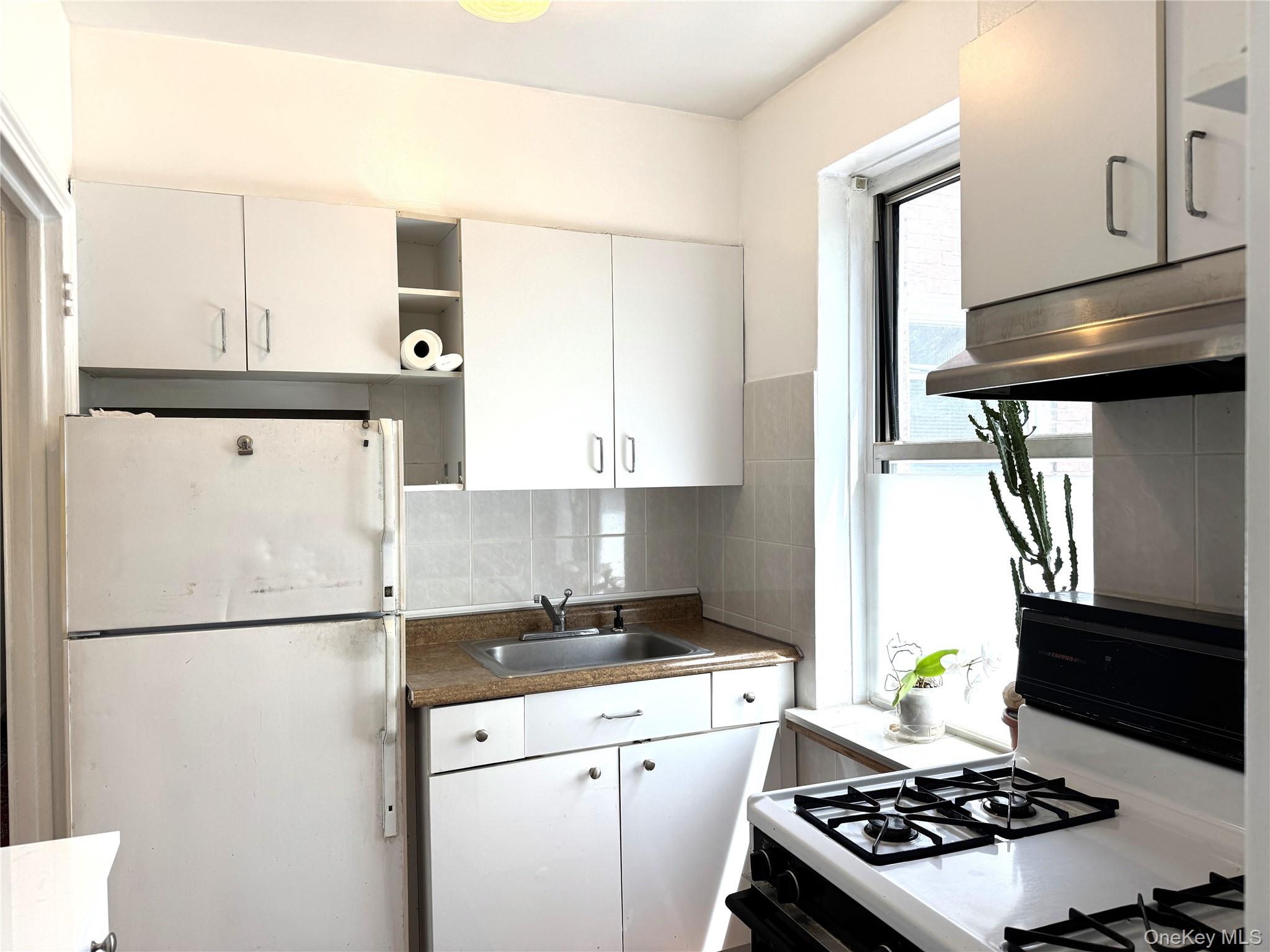 141-24 78th Road, Unit 3A Queens, NY 11367 - Photo 9 of 18 a kitchen with a refrigerator and a stove top oven