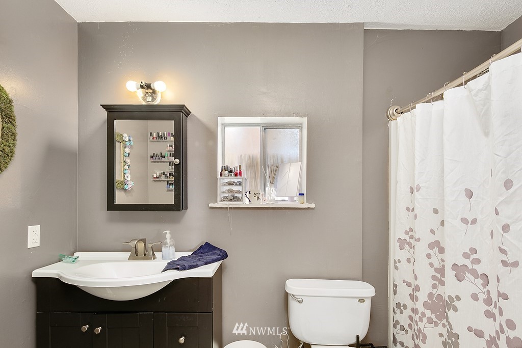 12008 Gibson Road Everett, WA 98204 - Photo 7 of 32 a bathroom with a toilet sink and mirror