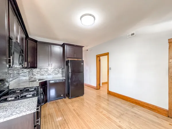 a kitchen with stainless steel appliances kitchen island granite countertop a refrigerator and a stove top oven