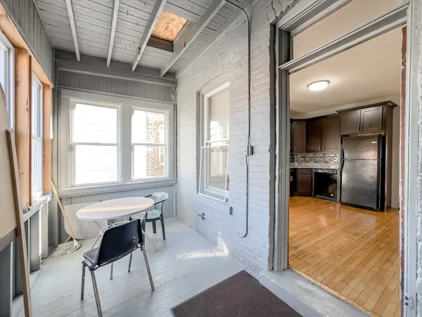 a view of a livingroom with kitchen and front door