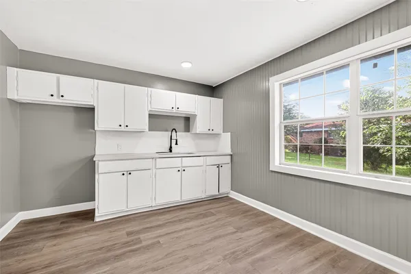 a kitchen with a sink wooden floor and windows