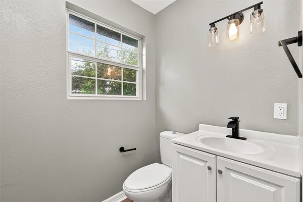 a bathroom with a sink a toilet and a window