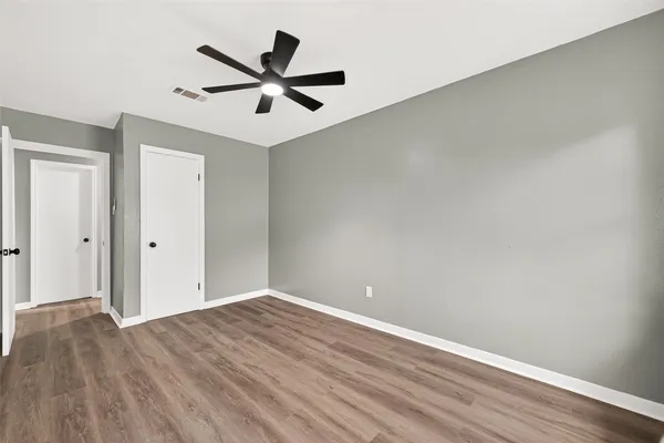 a view of a big room with wooden floor and a ceiling fan