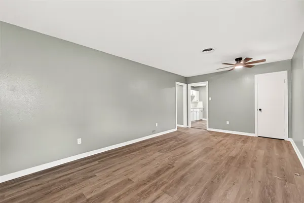 a view of an empty room with wooden floor