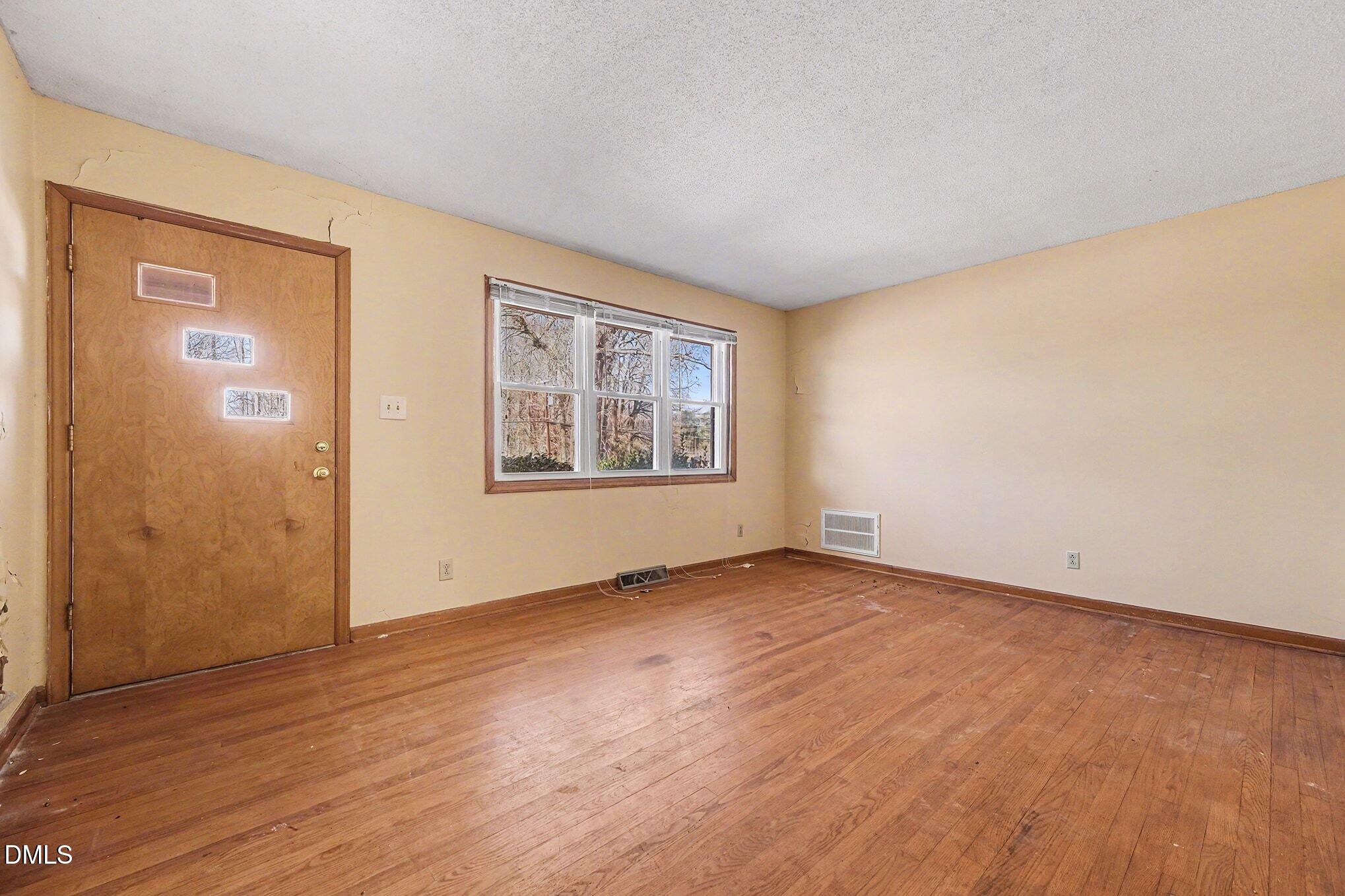 3312 Hamlin Road Durham, NC 27704 - Photo 13 of 37 a view of an empty room with wooden floor and a window