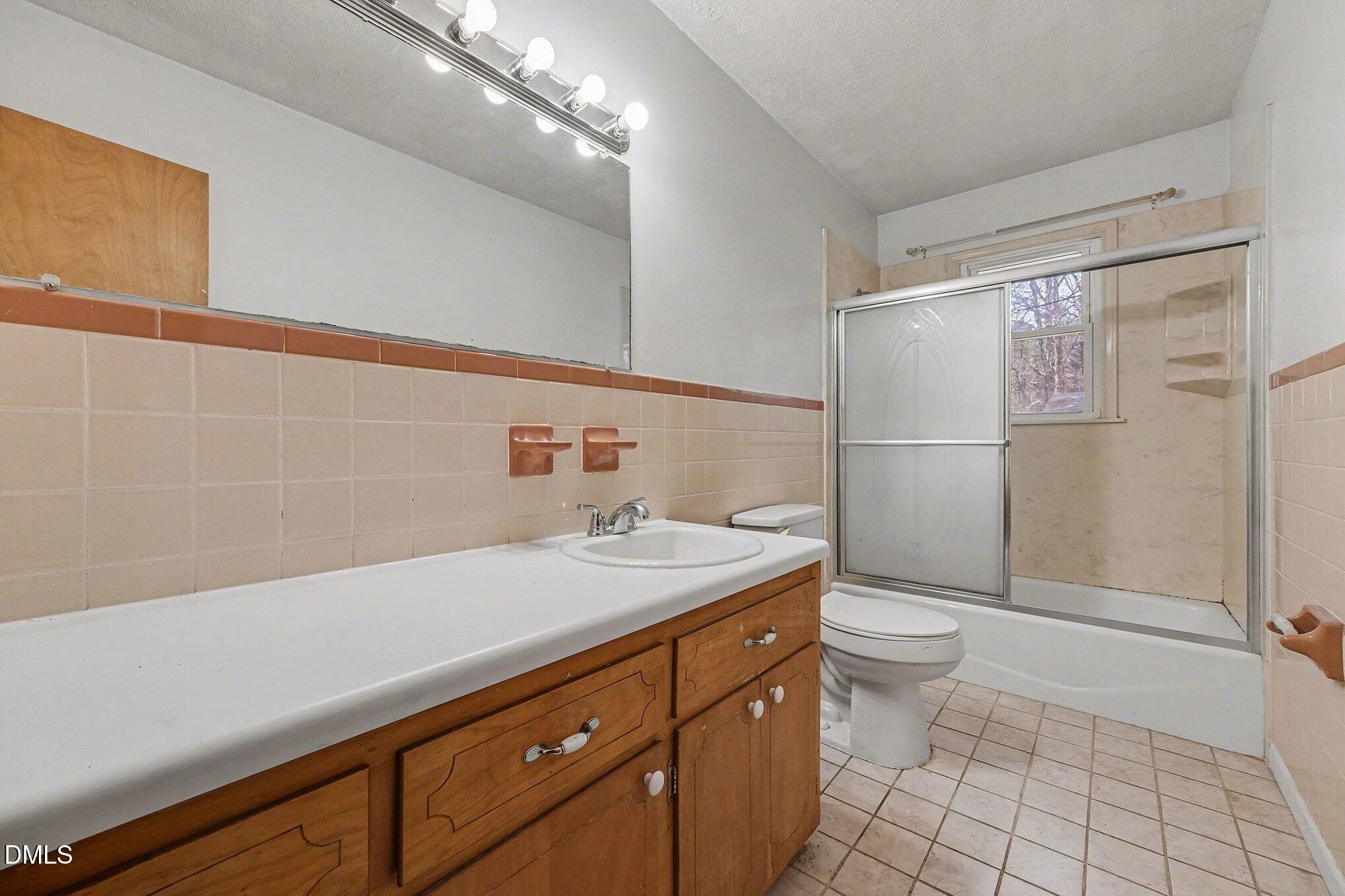 3312 Hamlin Road Durham, NC 27704 - Photo 20 of 37 a bathroom with a sink a toilet a mirror and shower