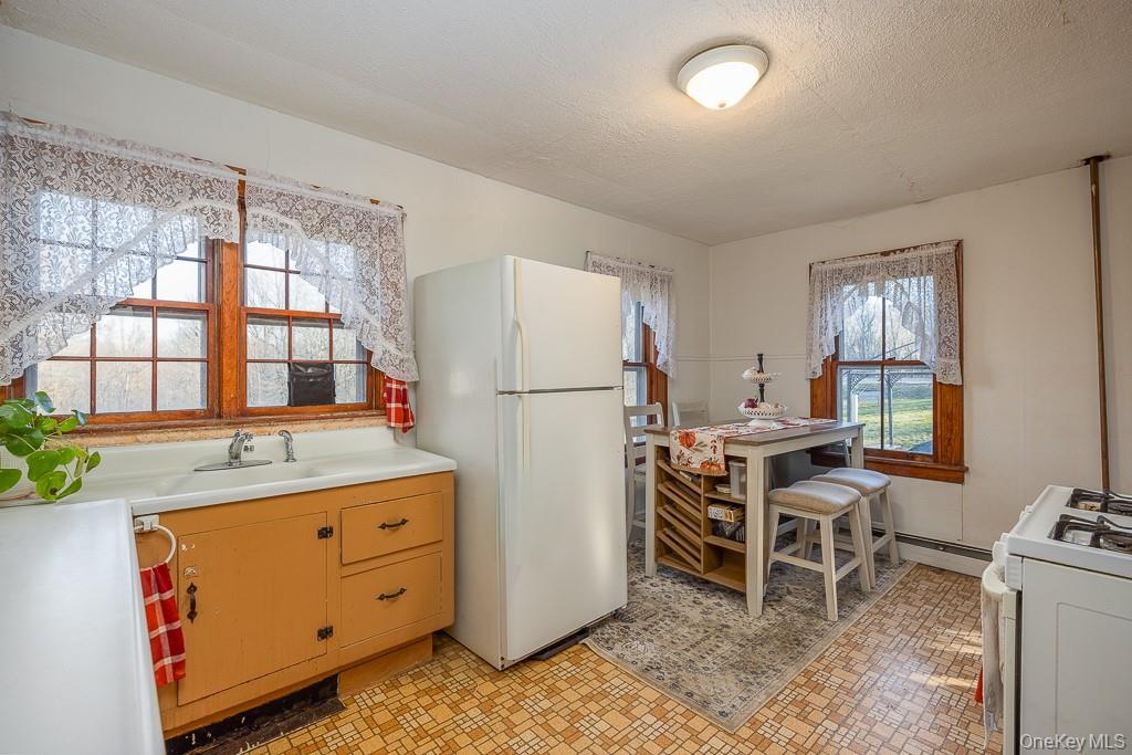 355 Fosler Road Wallkill, NY 12589 - Photo 12 of 33 Kitchen featuring white appliances, light countertops, a textured ceiling, and light floors