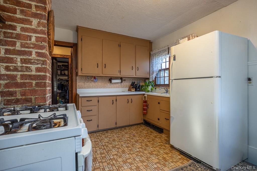 355 Fosler Road Wallkill, NY 12589 - Photo 13 of 33 Kitchen featuring white appliances, light countertops, a textured ceiling, and light flooring