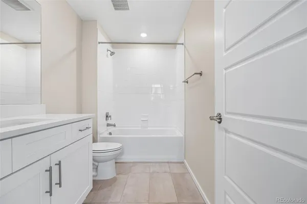 a bathroom with a bathtub toilet sink vanity and shower