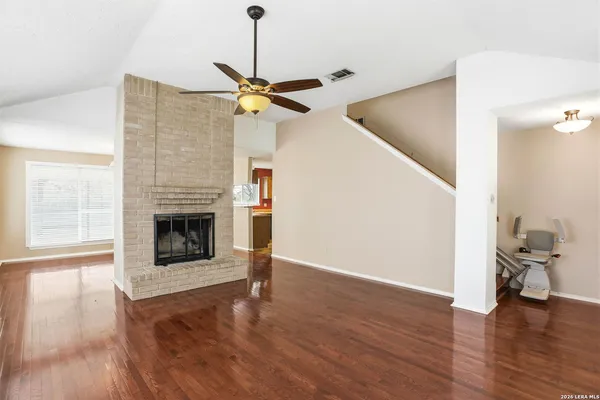 a view of a livingroom with wooden floor and a ceiling fan