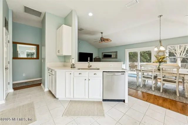 a kitchen with white cabinets and sink