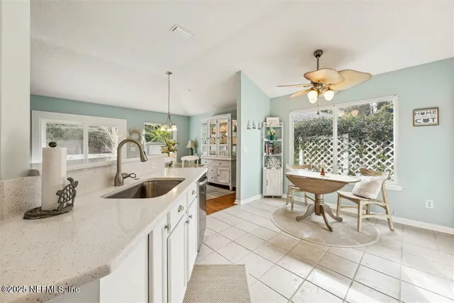 a kitchen with a sink and chairs