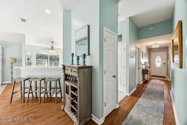 a view of a hallway to a livingroom with furniture and windows