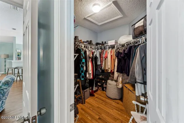a view of walk in closet with clothes and shoes