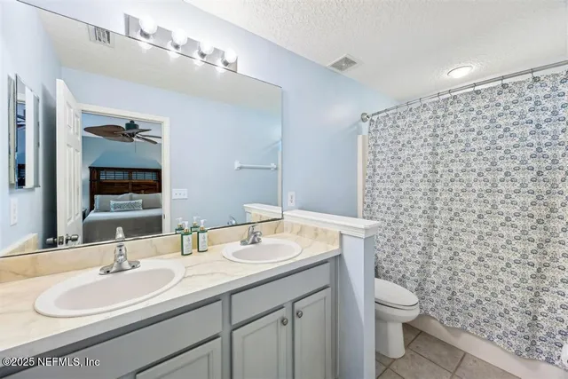 a bathroom with a sink a toilet and a mirror