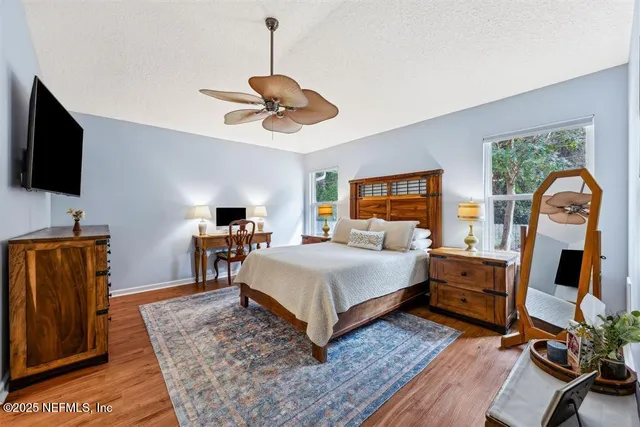 a bedroom with a bed a flat screen tv and dresser