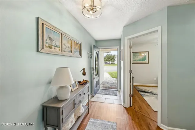 a view of a hallway to a livingroom with furniture