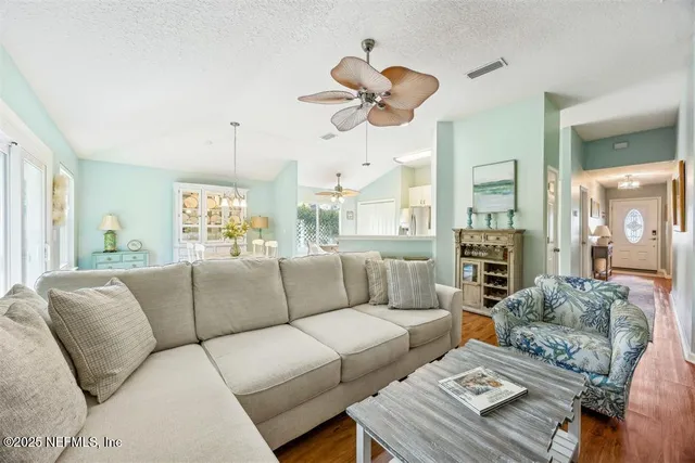 a living room with furniture a large window and a chandelier