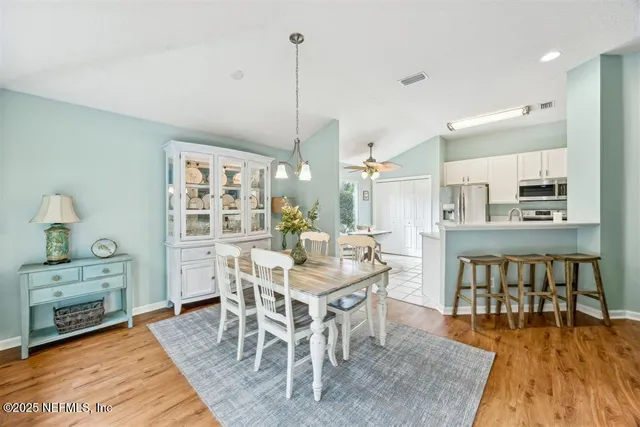 a dining room with furniture a chandelier and wooden floor