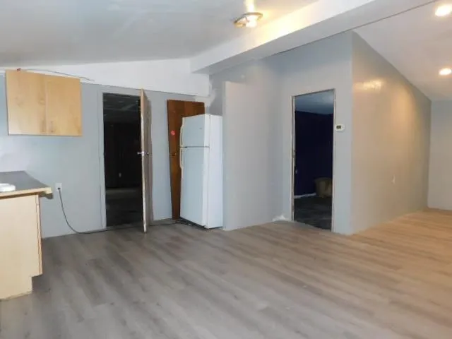 a view of empty room with wooden floor