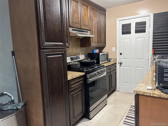 a kitchen with stainless steel appliances granite countertop a stove top oven a sink and dishwasher