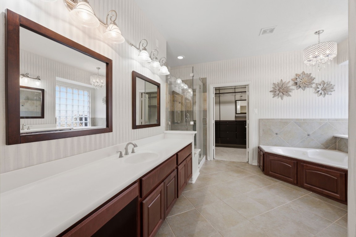 315 Arbor Ridge Lane Conroe, TX 77384 - Photo 21 of 47 The primary ensuite boasts two separate vanity areas, a corner soaking tub and separate shower.