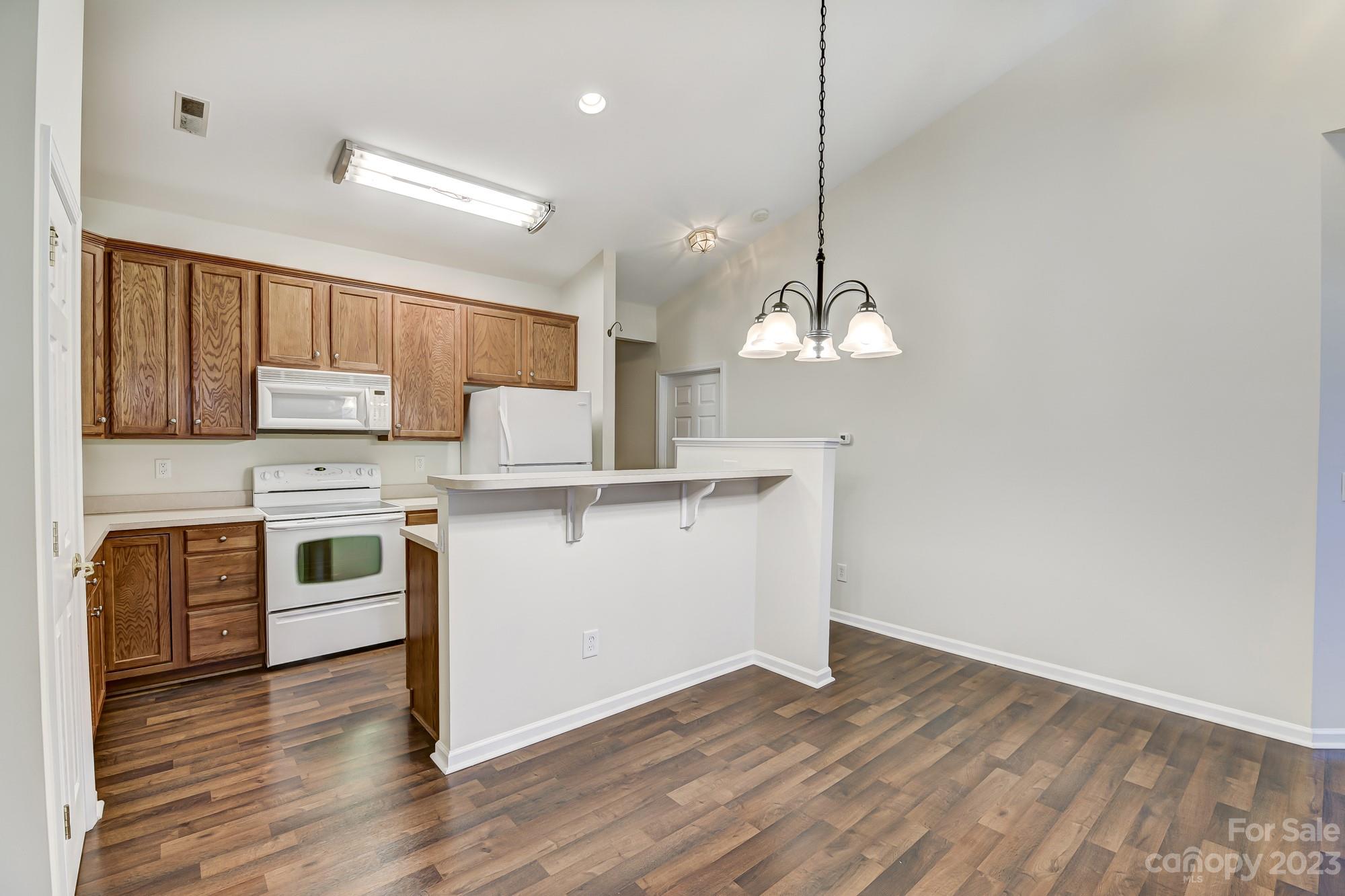 3253 Sapphire Lane Fort Mill, SC 29708 - Photo 6 of 35 a kitchen with stainless steel appliances granite countertop a stove a sink dishwasher and a refrigerator with wooden floor