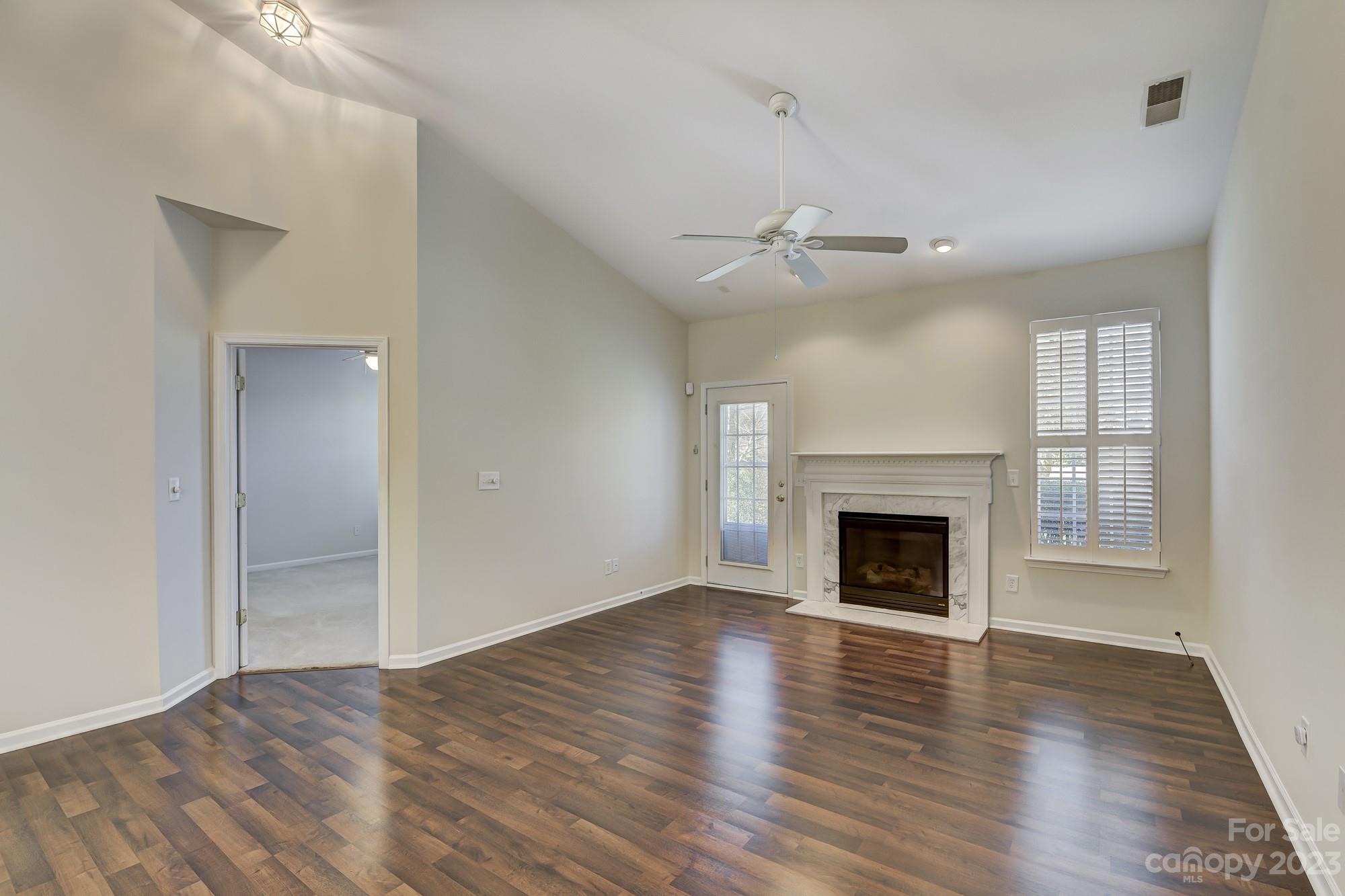 3253 Sapphire Lane Fort Mill, SC 29708 - Photo 9 of 35 an empty room with wooden floor fireplace and windows