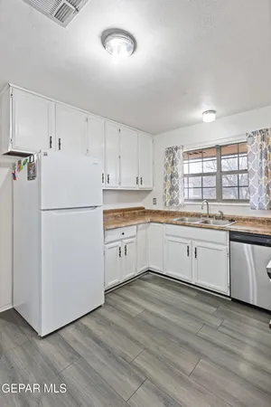 a kitchen with granite countertop white cabinets and white appliances