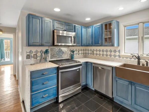 a kitchen with kitchen island granite countertop a sink stove and refrigerator